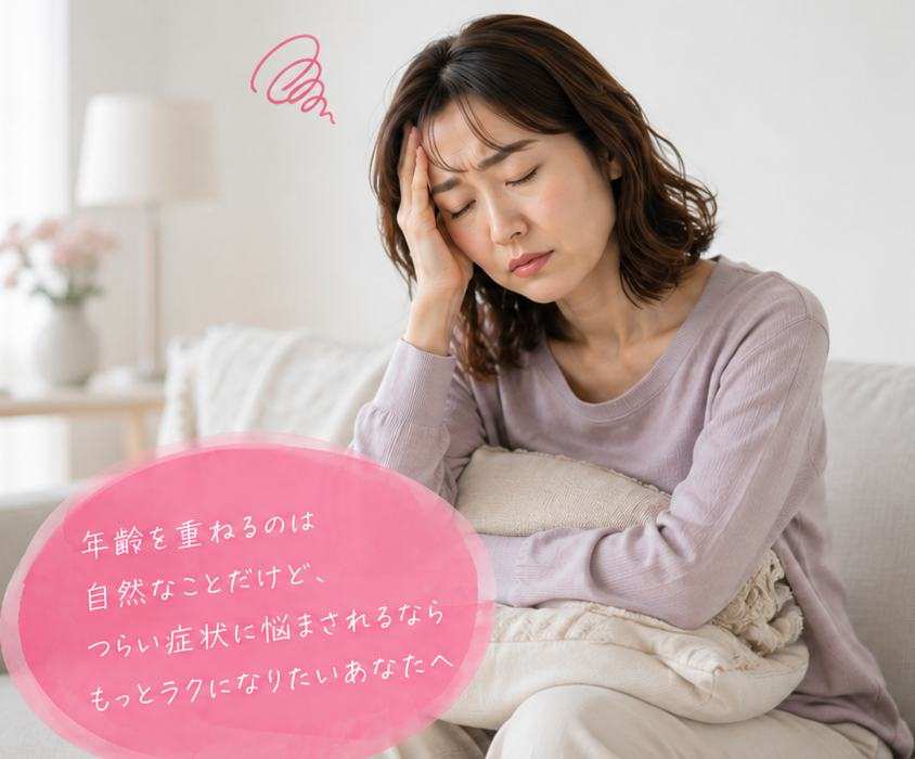 ソファでクッションを抱えてこめかみを押さえる女性。年齢を重ねるのは自然なことだけど、つらい症状に悩まされるならもっとラクになりたいあなたへ
